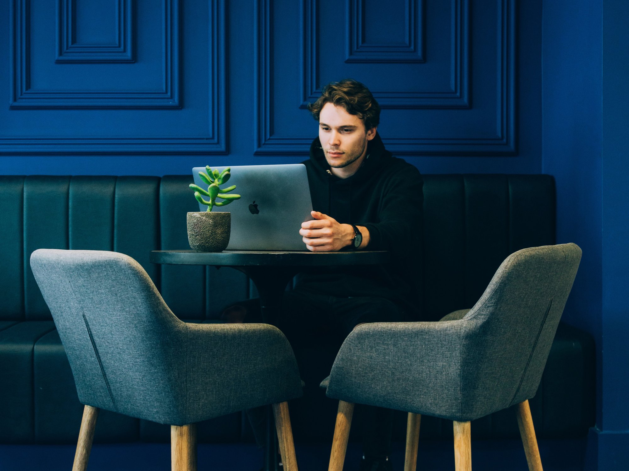 Man sitting at a table looking at his laptop